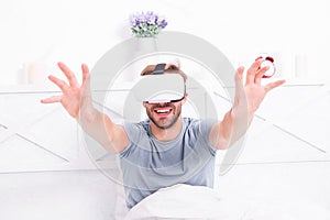 Using computer technology to create a simulated environment. Happy guy wearing VR headset for computer gaming. Handsome