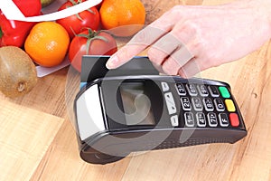 Payment terminal with credit card, fruits and vegetables, cashless paying for shopping