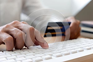 Using a credit card to pay online, use a smartphone for online shopping, a male hand holds a credit card