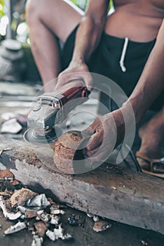 Using electric blades to sharpen coconut shells to be smooth