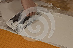 using a flat square trowel to smooth and spread cement