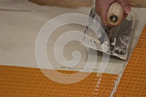 using a flat square trowel to smooth and spread cement