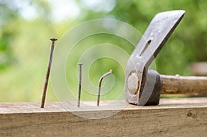 Using hammer and nails and curved nail on wood and bokeh background