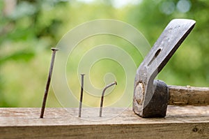 Using hammer and nails and curved nail on wood and bokeh background