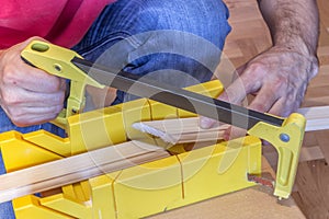 Using hand saw and miter box