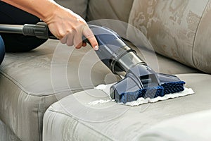 using a handheld vacuum to clean sofa crevices