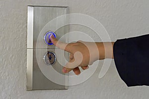 Using hands, press the elevator up and keypad elevator