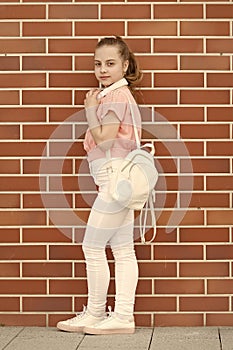 Using headset on move. Adorable little girl wearing wireless bluetooth headset. Fashionable small child with adjustable