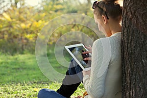 Using ipad young woman in the park