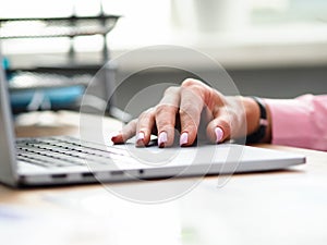 Using laptop for studies or work, hand on keyboard