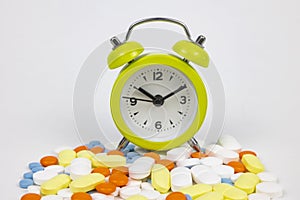 Using medicines in time concept. Clock on the pills isolated on white background
