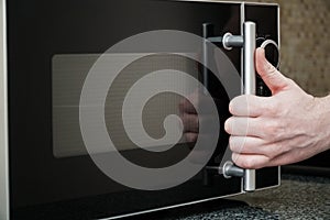 Using microwave oven in the kitchen, close up photo