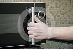 Using microwave oven in the kitchen, close up photo