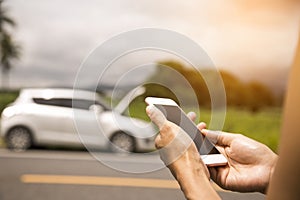 Using a mobile phone call a car mechanic because car was broken. photo