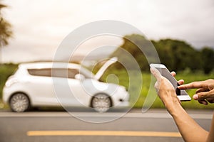Using a mobile phone call a car mechanic because car was broken. photo
