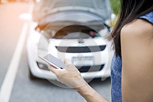 Using a mobile phone call a car mechanic because car was broken. photo