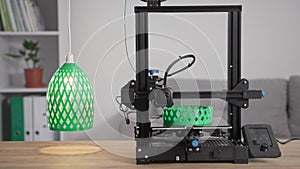 using modern technologies at home, the automatic 3D printer prints from molten green plastic a prototype of a plafond