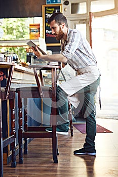 Using modern technology to advertise his startup. a young man using a digital tablet while working in a coffee shop.