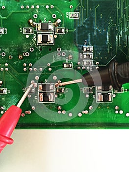 Using multimeter probes to examine a PCB