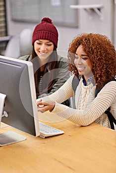 Using online resources to their advantage. two female students studying together at a computer in the library.