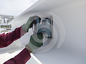 Using a Ponceuse Vibrante or Orbital Sander to scrub surface intermediate fire proof paint before painting top coat photo