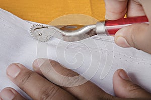 Using of Sewing Tracing Wheel on White Fabric.