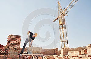 Using showel. Construction worker in uniform and safety equipment have job on building