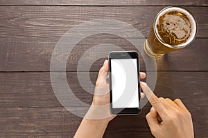 Using smartphone beside of beer in the pub