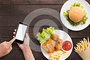 Using smartphone with burger, french fries and fried chicken set