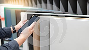 Using smartphone while choosing cabinet materials