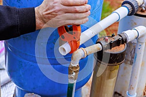 Using special pair of scissors, plumber cuts a plastic PVC pipe