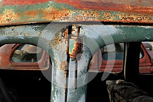 Using a spike as a hinge pin in an old rusty car.