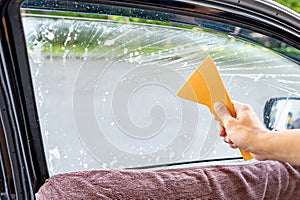 Using squeegee blade cleaning old car window film tint