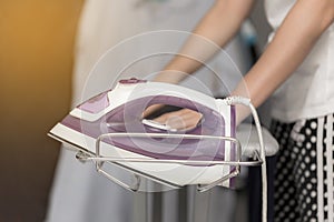 Using steam iron on her cloths