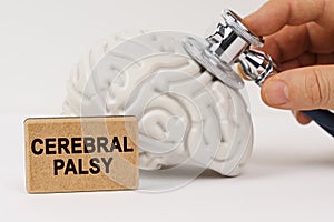 Using a stethoscope, the brain is diagnosed, next to it is a sign with the inscription - CEREBRAL PALSY