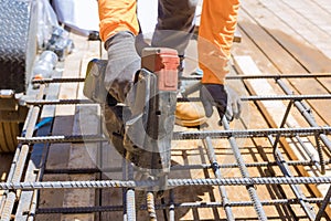 Using this tool, construction workers twist reinforcement wires with steel bars for cement foundations