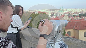 Using tourist binoculars to observe the city. Prague.