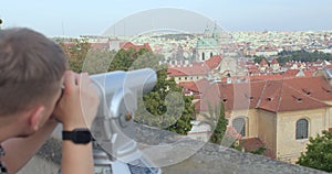 Using tourist binoculars to observe the city. Prague.