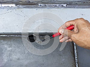Using welding inspection mirror for check visual welding defects in a niche photo