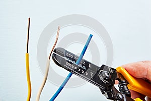 Using wire stripper cutter during electrical wiring installati photo