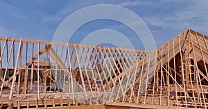 Using wooden frame trusses to support beams for construction of a new roof for house