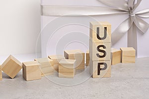 usp - letters on wooden cubes. concept on white gift box background