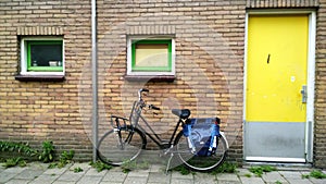 The usual Amsterdam entrance in a residential house, near a parked bike. Bright yellow front door