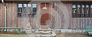 Usual rotten   wooden vintage  wall of rural shed with old door  for storage of firewood and agricultural tools