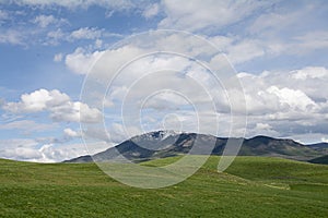 Utah Snow capped mountains with rolling green hills