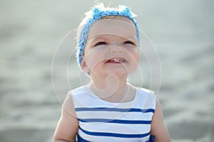 ÃÂ¡ute baby girl in nice striped dress and blue headband smiling and showing her first teeth