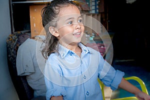 ute boy with long hair smiling happily He was wearing a blue t-shirt.