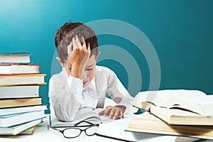 Ð¡ute boy reading difficult book at the table, blue background