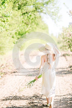 Ð¡ute dreamy toddler child girl walking in blooming spring garden.