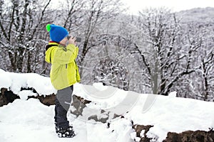 Ð¡ute kid nature explorer in winter forest. Little boy binoculars explorer at winter nature. Winter vacation